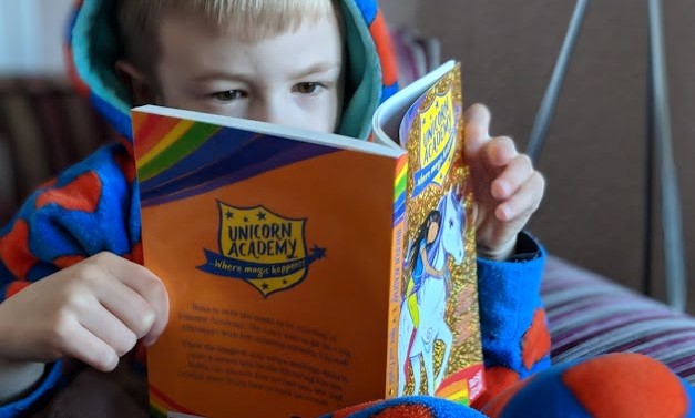 child reading unicorn academy book