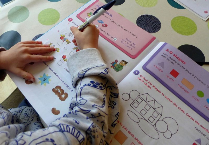 child completing a maths book