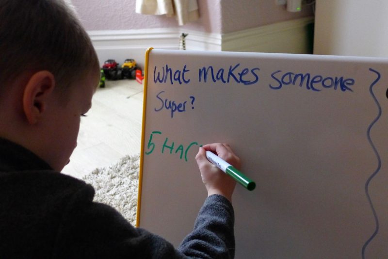 child writing on teacher board