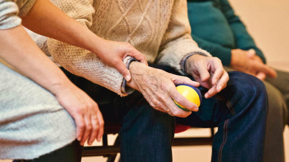 elderly person holding fruit and beinr cared for